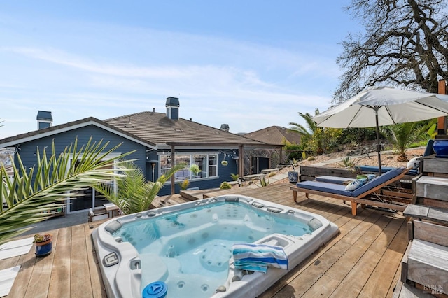 view of pool featuring a deck and hot tub deck surround