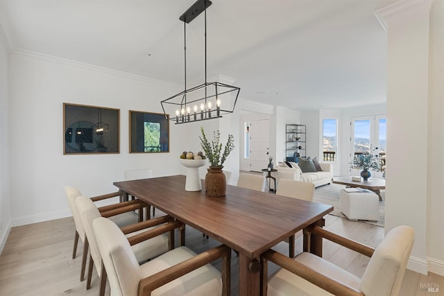 dining space featuring ornamental molding, baseboards, and light wood finished floors