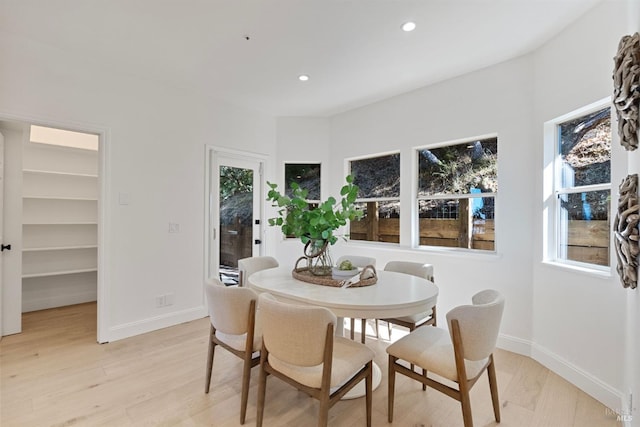 dining room featuring light wood finished floors, baseboards, and recessed lighting