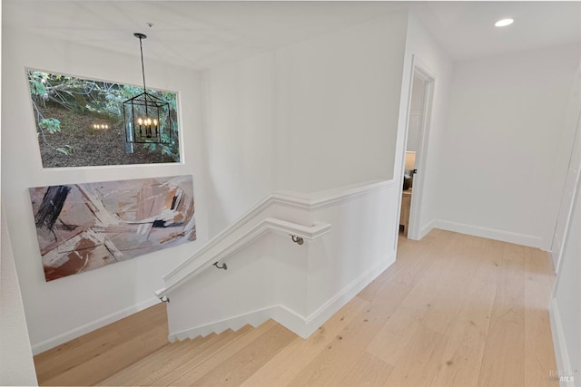 hall with baseboards, a chandelier, wood finished floors, and recessed lighting