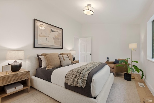 bedroom featuring light wood-style floors, baseboards, and visible vents