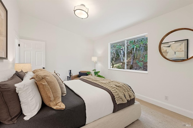 bedroom with wood finished floors and baseboards