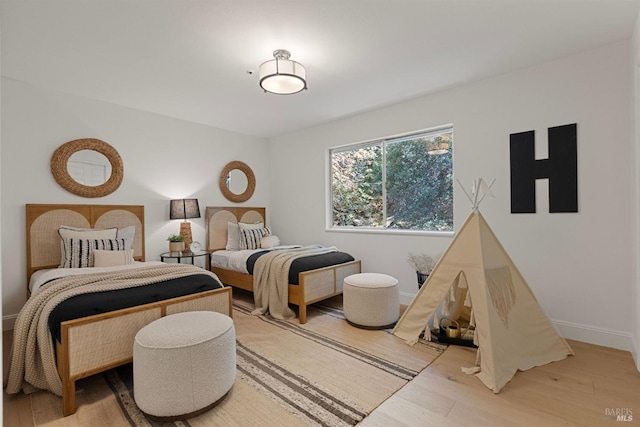 bedroom with light wood-type flooring and baseboards