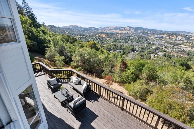 wooden deck featuring a mountain view, an outdoor living space, and grilling area