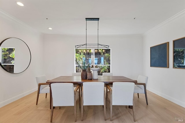 dining space with a healthy amount of sunlight, light wood-style flooring, and ornamental molding