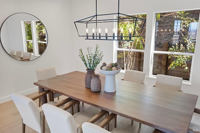 dining room featuring an inviting chandelier, baseboards, and wood finished floors