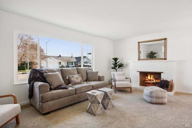 carpeted living area with a brick fireplace and baseboards