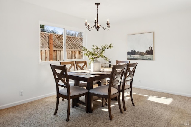 dining space with carpet, a notable chandelier, and baseboards