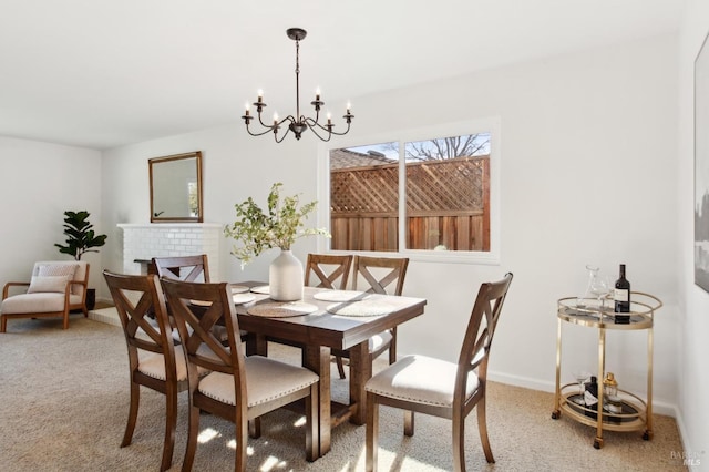 carpeted dining area with a chandelier and baseboards