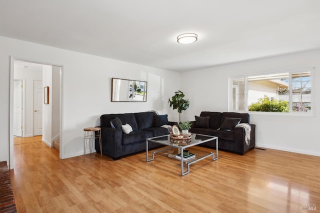 living room featuring light wood-type flooring and baseboards