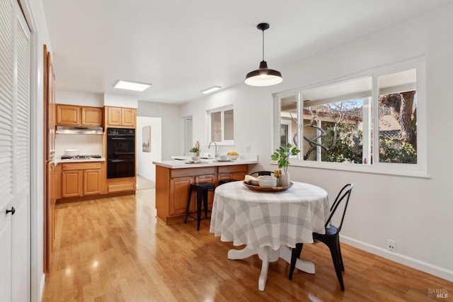 dining space featuring light wood-type flooring and baseboards