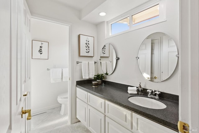 bathroom with baseboards, vanity, toilet, and tile patterned floors