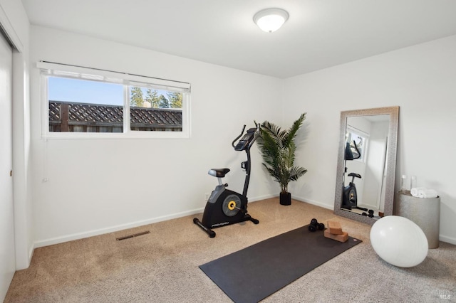 exercise room featuring carpet floors, visible vents, and baseboards