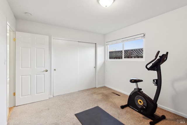 workout area featuring baseboards, visible vents, and carpet flooring