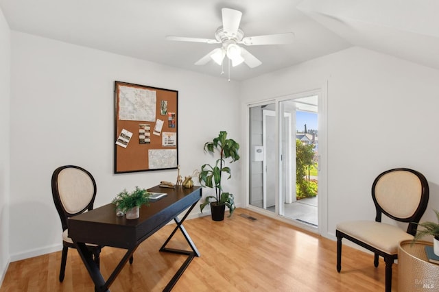 office area with light wood-style flooring, visible vents, vaulted ceiling, and a ceiling fan