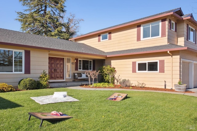 view of front facade featuring a garage, roof with shingles, and a front yard