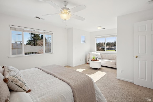 bedroom with baseboards, a ceiling fan, visible vents, and light colored carpet