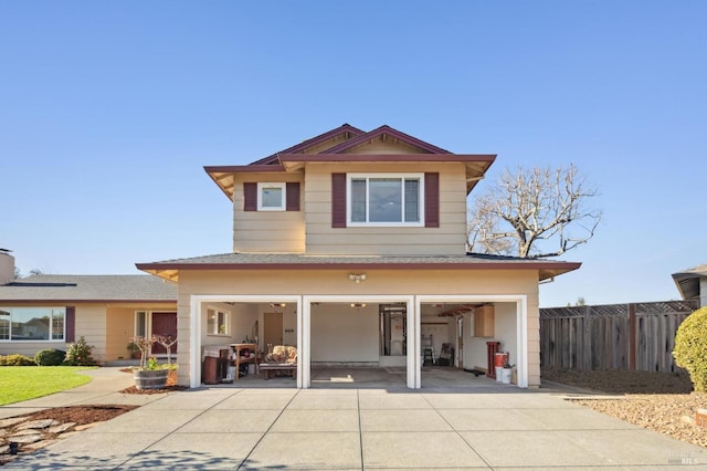 view of front of home featuring fence and concrete driveway