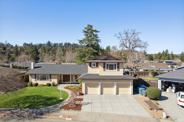 view of front of house with a shingled roof, concrete driveway, an attached garage, fence, and a front lawn