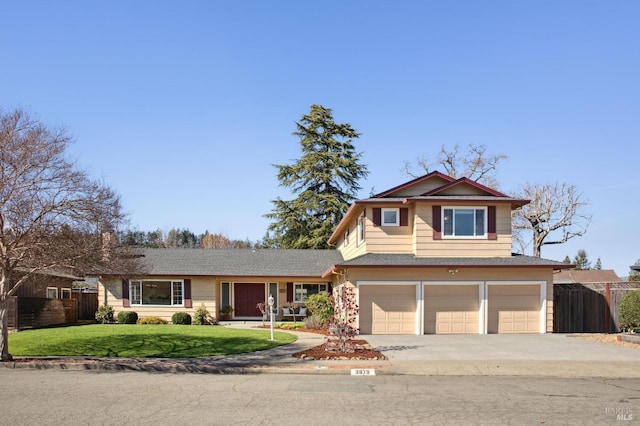 traditional-style home with a garage, a front yard, concrete driveway, and fence