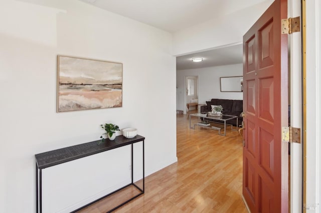 hall featuring light wood-type flooring and baseboards