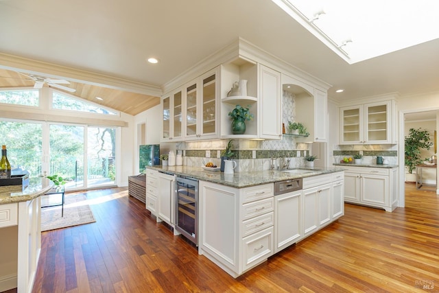 kitchen featuring tasteful backsplash, beverage cooler, white cabinets, open shelves, and a sink