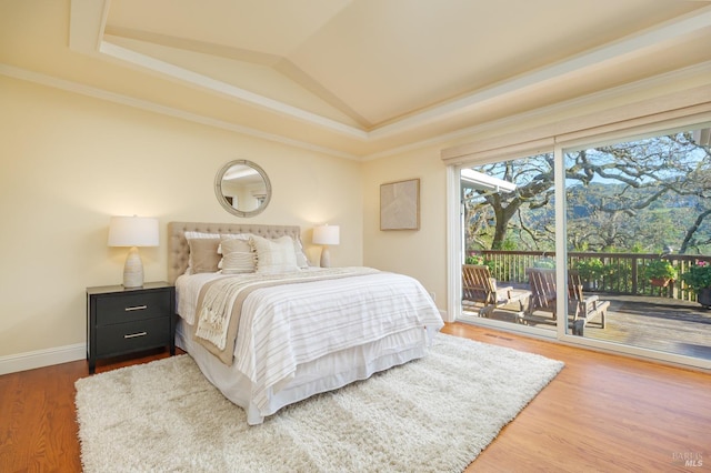 bedroom featuring wood finished floors, baseboards, vaulted ceiling, access to exterior, and crown molding