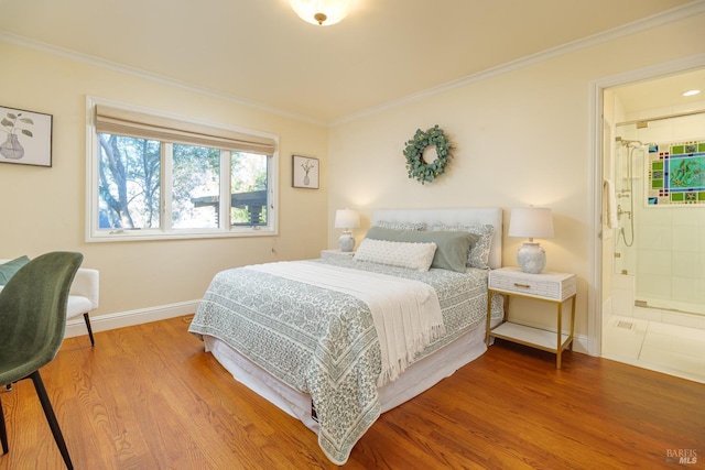 bedroom featuring ensuite bath, baseboards, ornamental molding, and wood finished floors