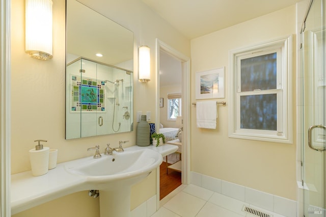 bathroom featuring a stall shower, tile patterned flooring, visible vents, and baseboards