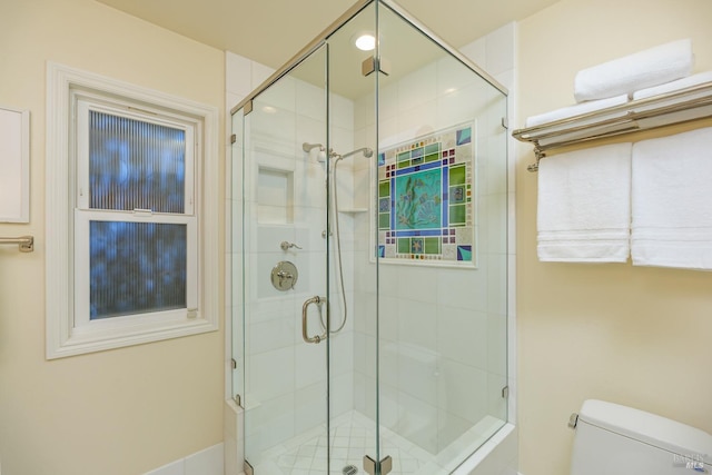 bathroom with a stall shower and toilet