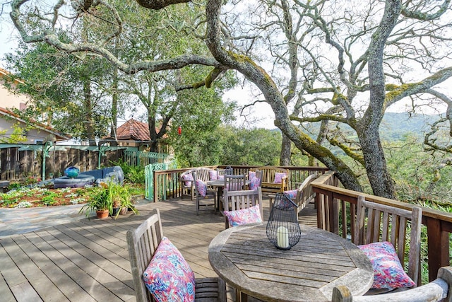 deck with outdoor dining space and fence