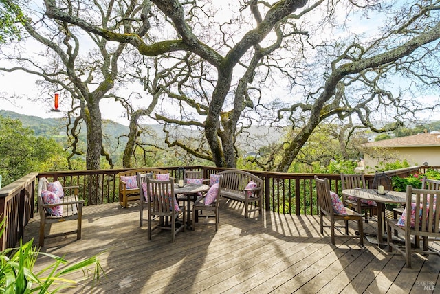 wooden terrace featuring outdoor dining space and a mountain view