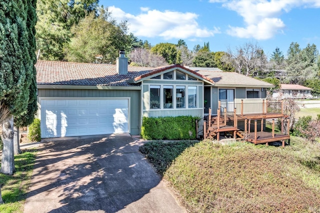 ranch-style home with a tile roof, driveway, a chimney, and an attached garage