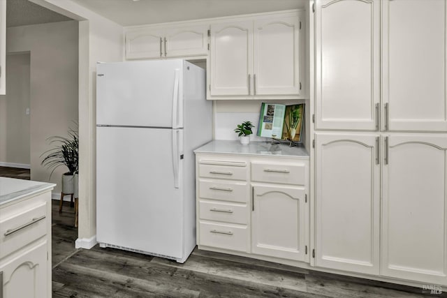 kitchen with white cabinetry, light countertops, dark wood-type flooring, and freestanding refrigerator