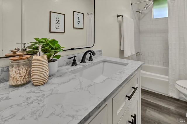 full bath with toilet, shower / tub combo, wood finished floors, and vanity