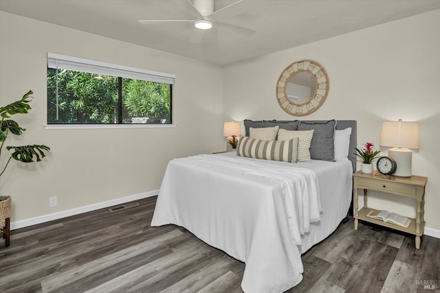 bedroom with a ceiling fan, visible vents, baseboards, and wood finished floors