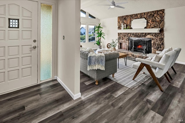 entryway with baseboards, a ceiling fan, lofted ceiling, dark wood-style flooring, and a fireplace