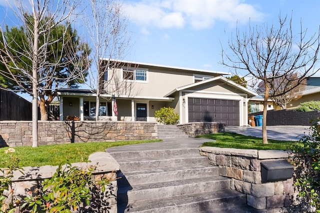 view of front of house featuring concrete driveway, an attached garage, fence, and stucco siding