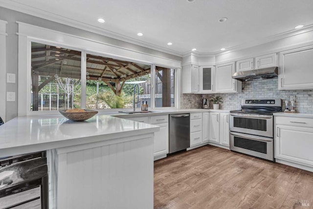 kitchen featuring under cabinet range hood, beverage cooler, plenty of natural light, and stainless steel appliances