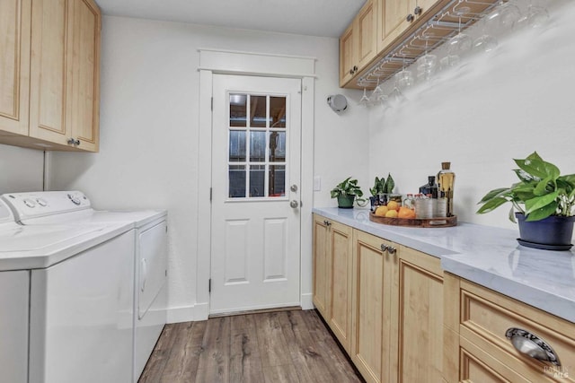 laundry room with separate washer and dryer, dark wood-style flooring, and cabinet space