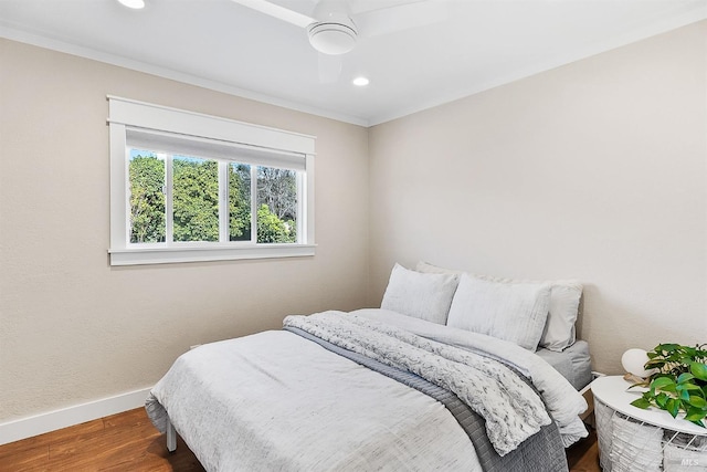 bedroom with recessed lighting, crown molding, baseboards, and wood finished floors