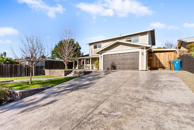 view of front of house with an attached garage, fence, a front lawn, and concrete driveway