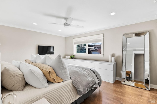 bedroom with light wood-style floors, ceiling fan, baseboards, and crown molding