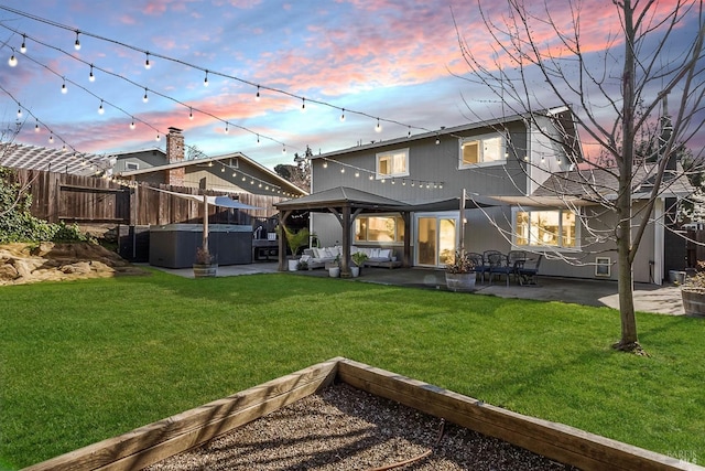 back of property featuring a yard, a patio area, a fenced backyard, and a hot tub