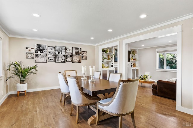 dining room featuring baseboards, ornamental molding, recessed lighting, and light wood-style floors