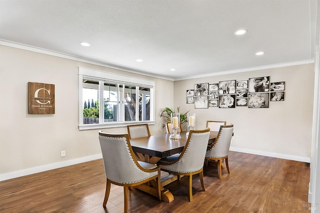 dining area featuring baseboards, wood finished floors, and crown molding