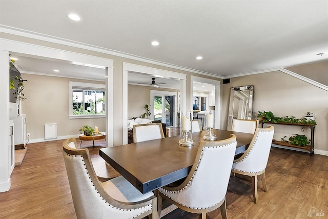 dining room with light wood finished floors, baseboards, and ornamental molding