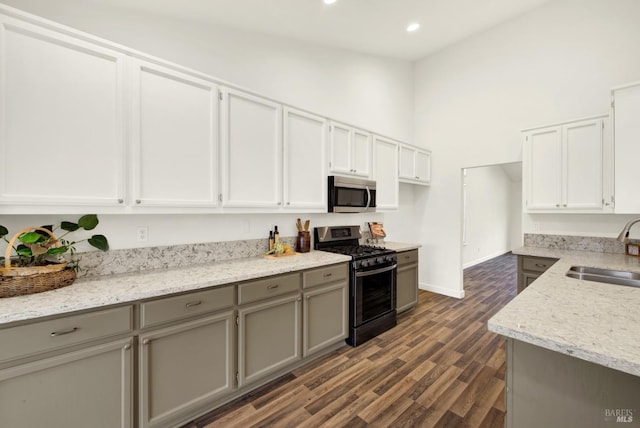 kitchen featuring recessed lighting, gray cabinets, dark wood-style floors, stainless steel appliances, and a sink