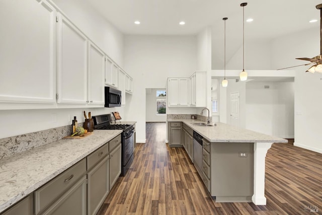 kitchen featuring a peninsula, gray cabinets, appliances with stainless steel finishes, and a sink