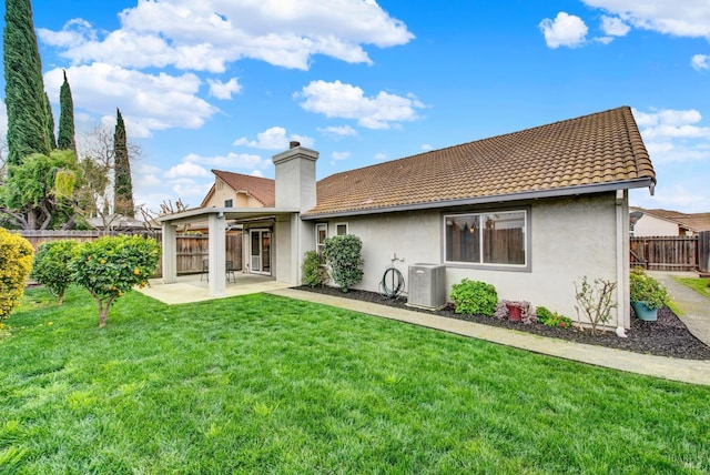 back of house featuring fence, a yard, stucco siding, a tiled roof, and a patio area